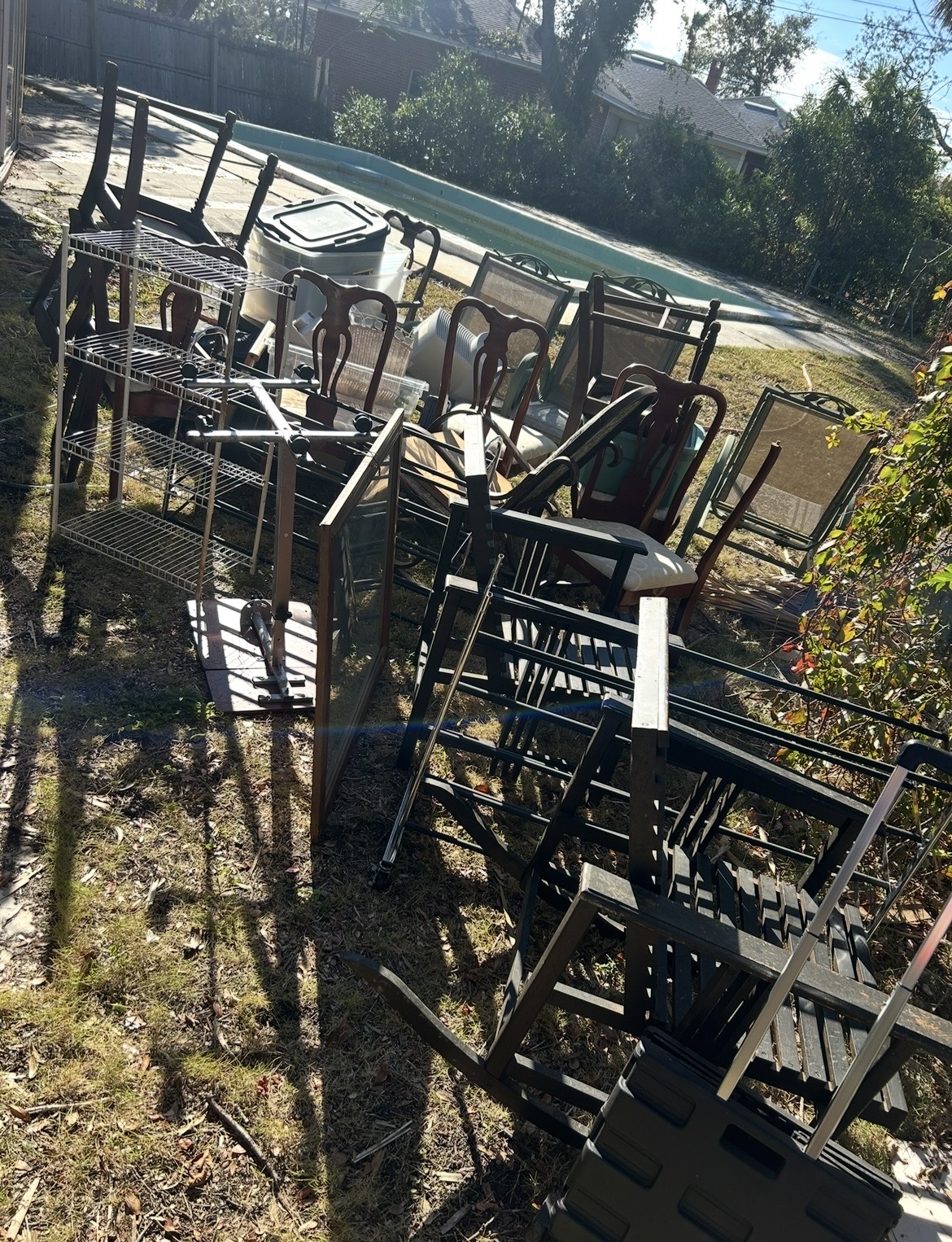 Backyard full of furniture and debris before removal